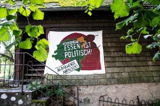 Transpi "Essen ist politisch" an der Wand eines Gebäudes