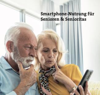 Ein älteres Paar schaut etwas ratlos auf das Smartphone